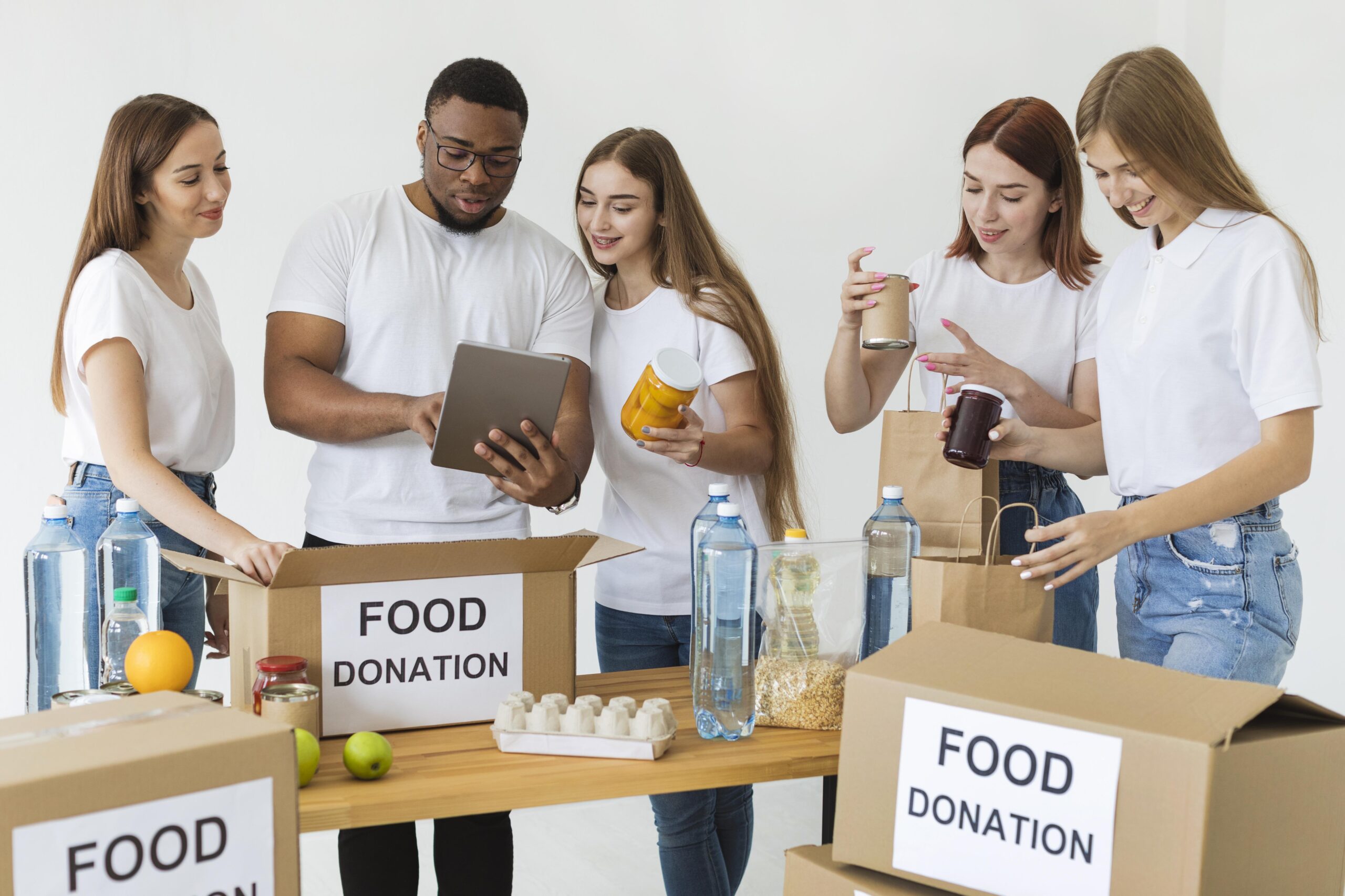 lots-volunteers-preparing-boxes-with-food-donations-using-tablet