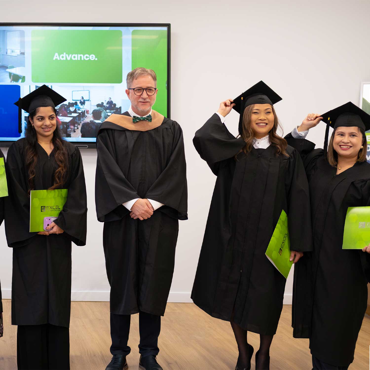 Graduates posing in caps and gowns at Excel Career College