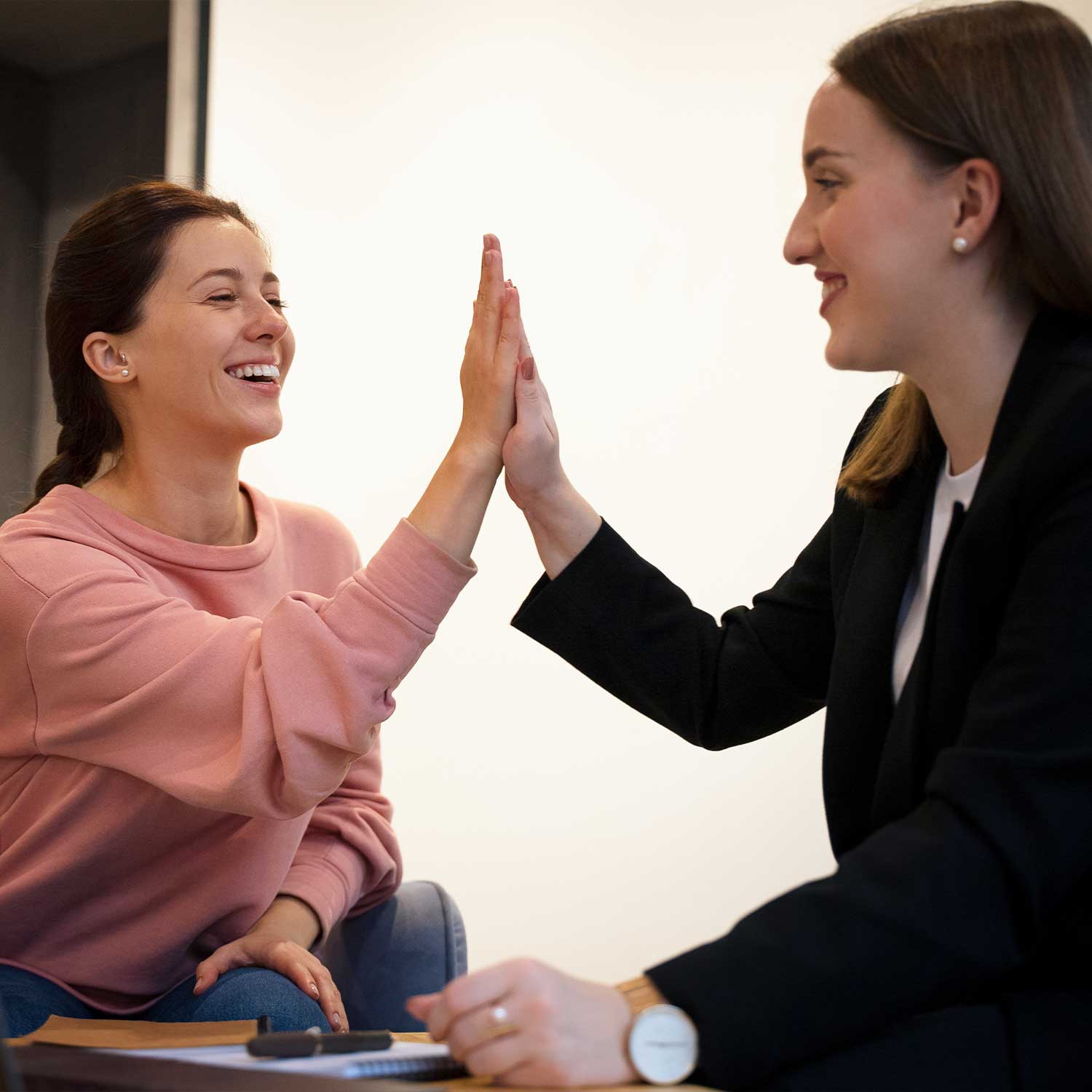 Two women giving high five to celebrate success and achievement